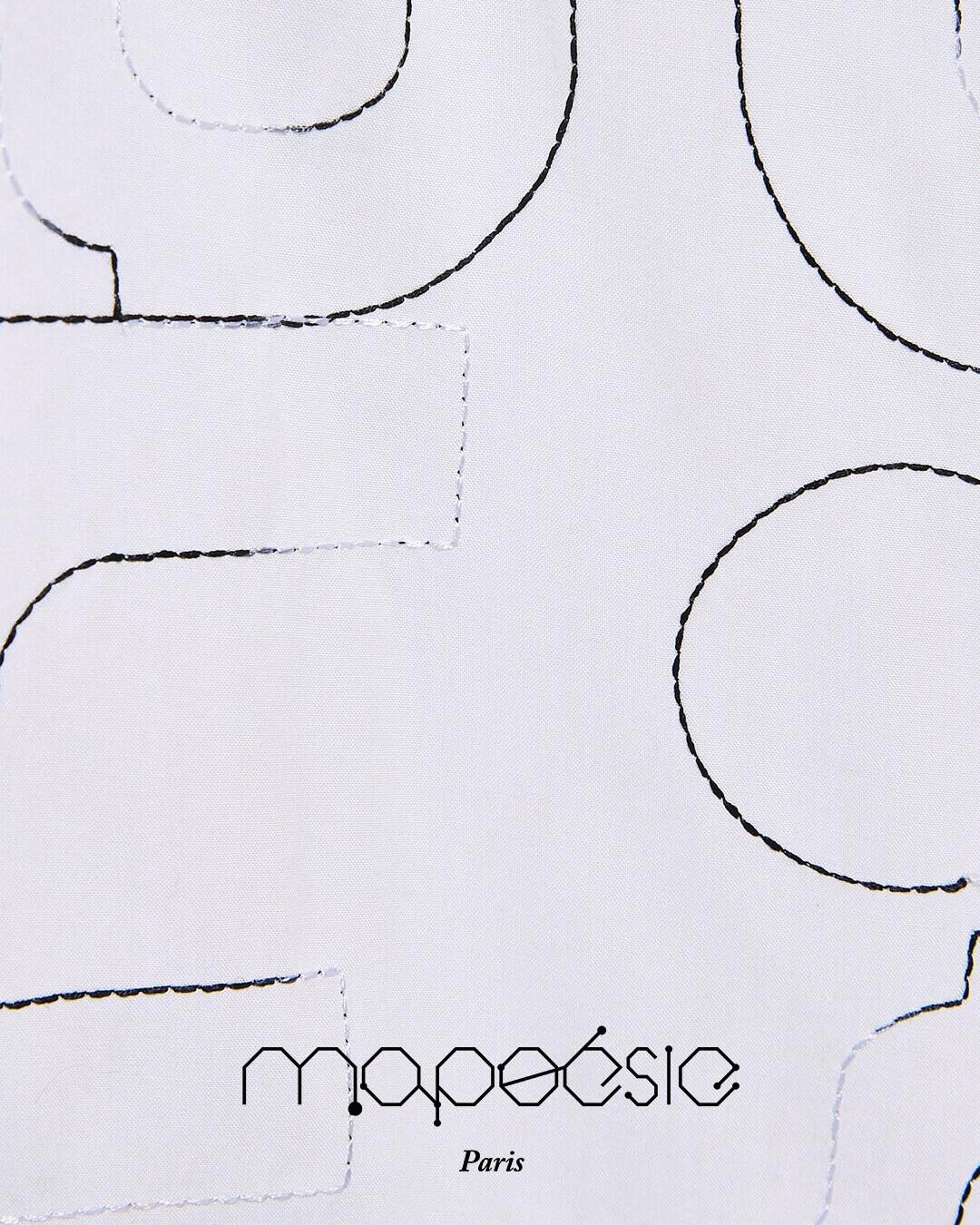 Quand le vêtement devient la toile d'un artiste. 
Cette blouse immaculée, traversée de traits délicats, se marie avec…